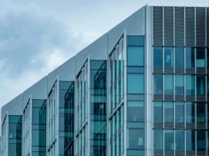 Modern glass office building against a blue sky